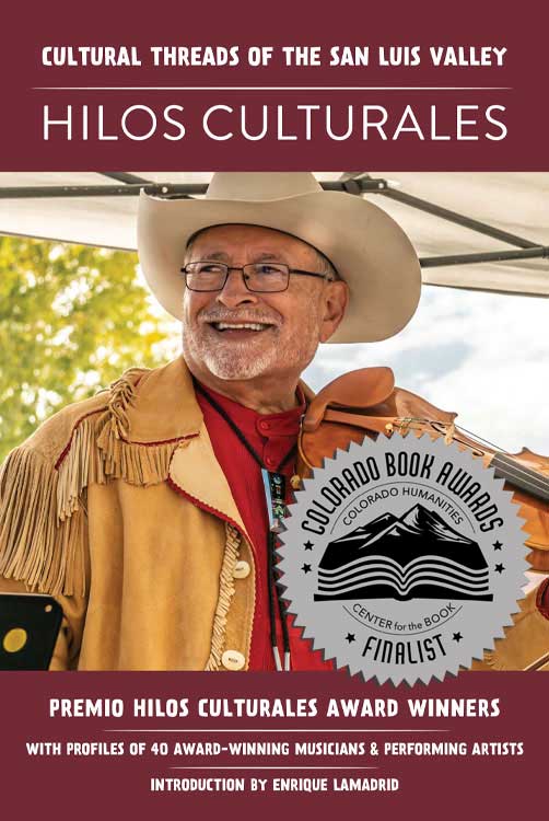 Hilos Culturales book cover with picture of smiling man wearing a cowboy hat and holding a fiddle. Colorado Book Awards sticker on front