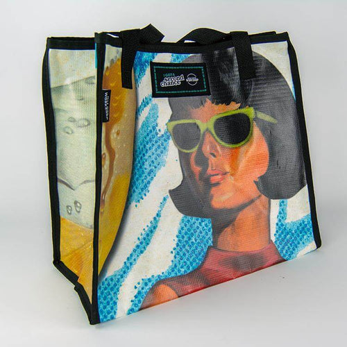 A bright colored limited edition banner tote bag with an illustration of a woman in retro sunglasses from History Colorado's Beer Here exhibition available in the History Colorado Shop